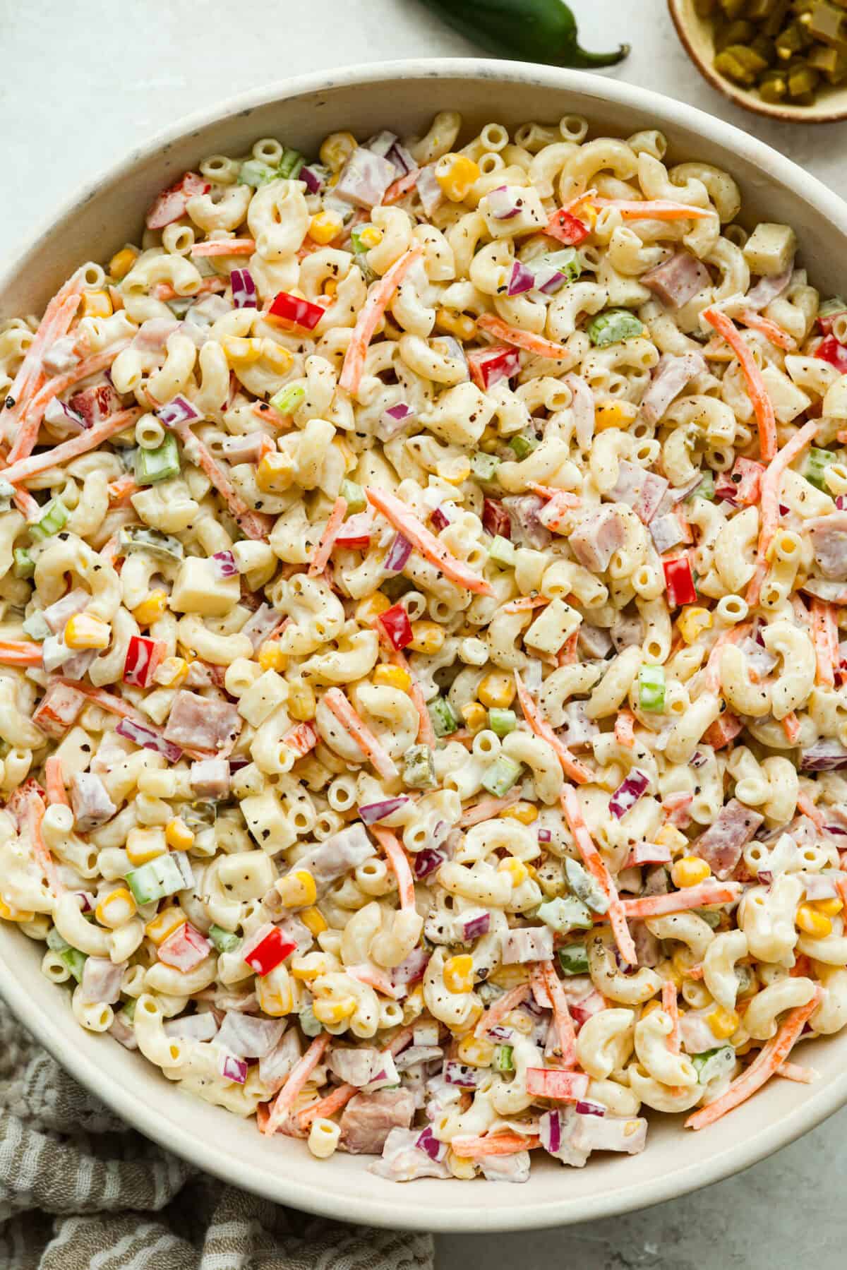 This Mexican macaroni salad is a fun twist on a classic! Itโs creamy, tangy, and full of flavor with crisp veggies, cheese, and a little kick from jalapeรฑos. Perfect for BBQs, potlucks, or anytime you want an easy, delicious side. Large bowl of Mexican macaroni salad.