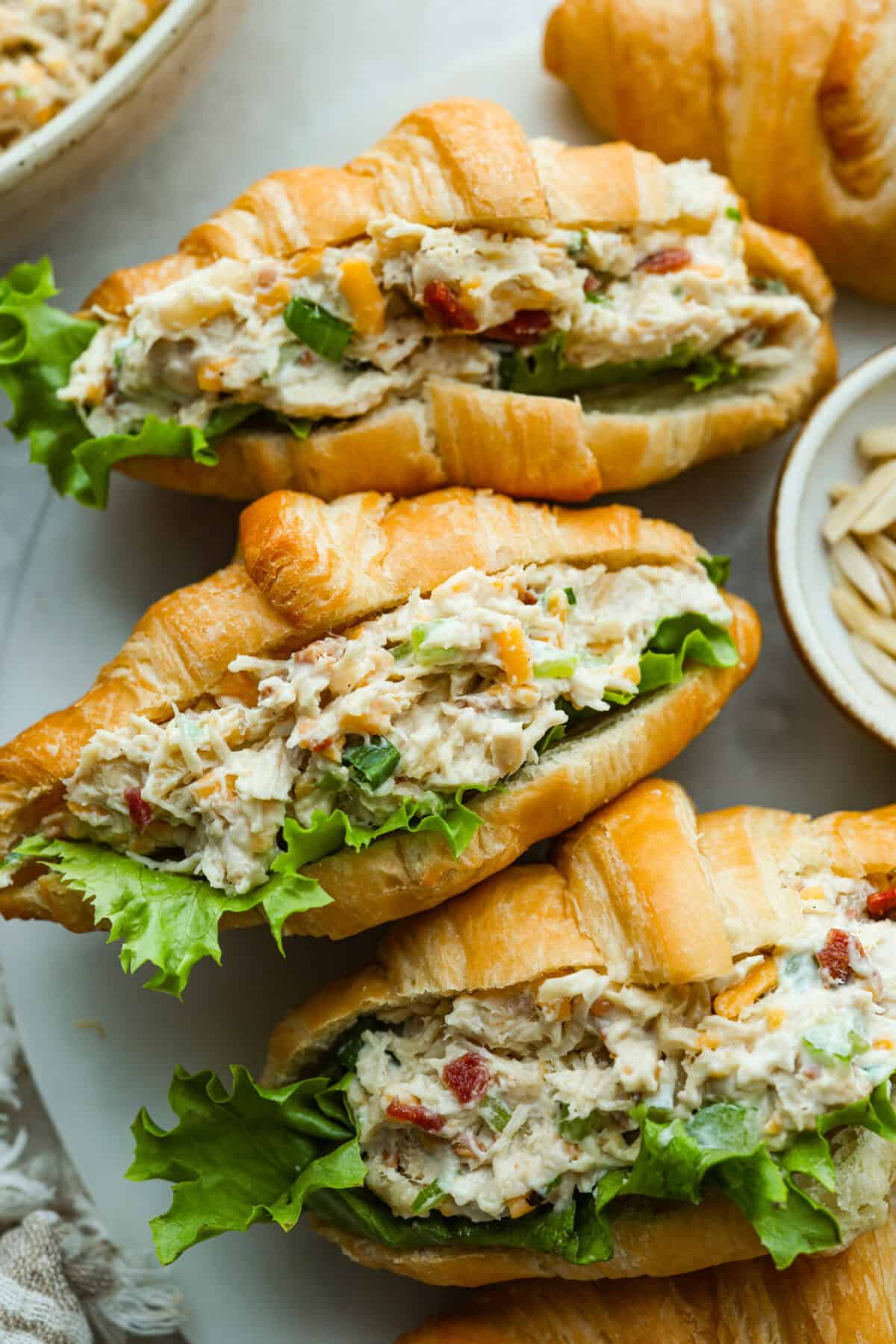 Million dollar chicken salad totally lives up to the name. Itโs creamy, cheesy, crunchy, and packed with bacon, so every bite is full of flavor. Serve it on croissants, with crackers, or straight from the bowl! It's that good. Croissants loaded with delicious million dollar chicken salad.