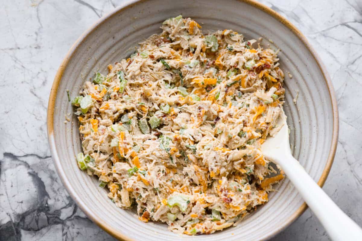Million dollar chicken salad totally lives up to the name. Itโs creamy, cheesy, crunchy, and packed with bacon, so every bite is full of flavor. Serve it on croissants, with crackers, or straight from the bowl! It's that good. All of the ingredients mixed together in a mixing bowl.