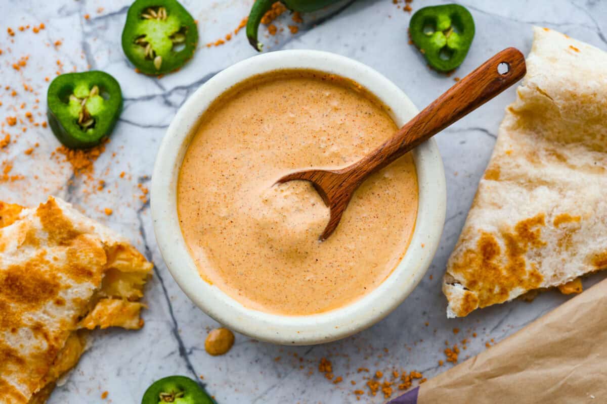 This copycat Taco Bell quesadilla sauce is about to become a staple in your fridge. Made with just four ingredients in five minutes, itโs a breeze to whip up. The taste is so spot-on, youโll be drizzling it on everything! Small bowl filled with Taco Bell quesadilla sauce.