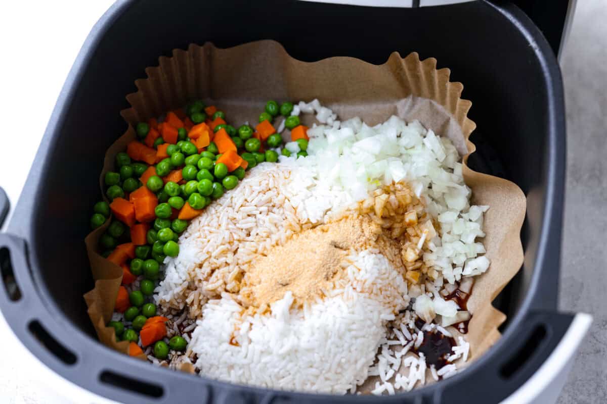 Did you know you can make fried rice in the air fryer? My Air Fryer Fried Rice recipe takes something already simple and makes it even easier. You get golden, slightly crispy rice, tender veggies, and the best flavor with hardly any effort. All of the ingredients for the rice, except the eggs, added to the liner in the air fryer basket.
