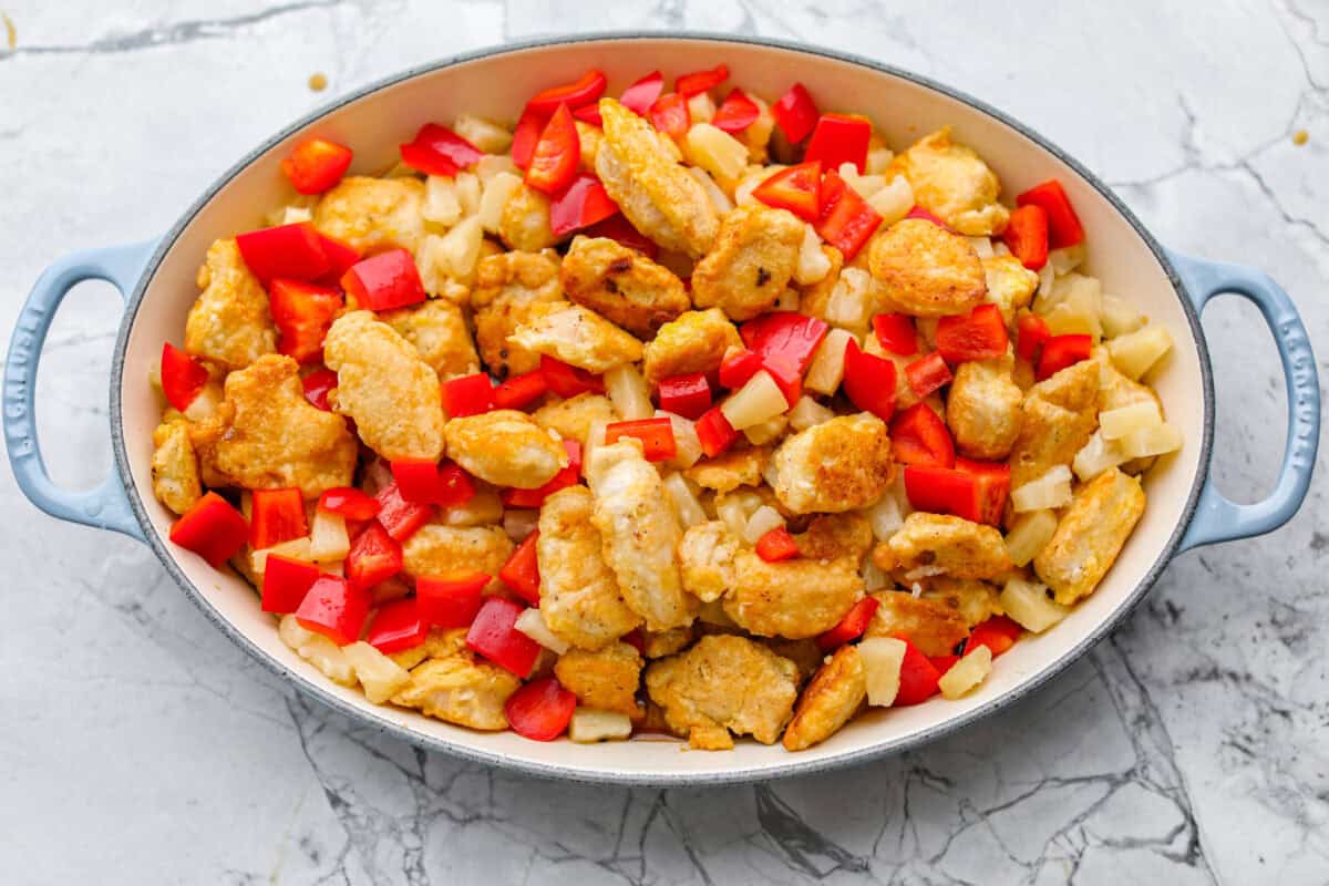 I'm updating my "Tuesday night dinner that feels like we're in Hawaii" with double the sauce! You guys asked, so I added more of that sweet, tangy, deliciousness to this Baked Sweet Hawaiian chicken! It's easy, even after a busy day! Veggies and pineapple added to the baking dish with the chicken. Ready to go in the oven to be baked to perfection.