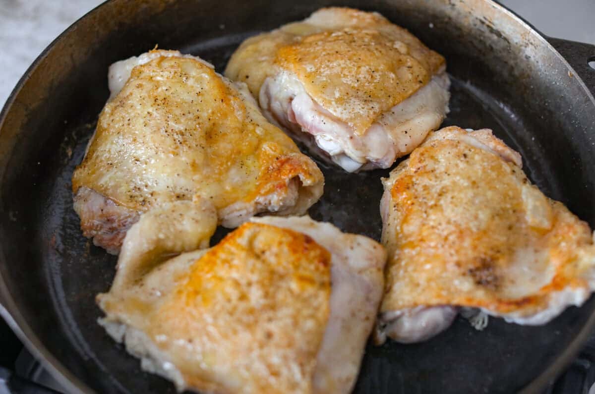 If cozy dinners are your thing, this creamy bacon mushroom thyme chicken needs to happen soon. Between the crispy chicken skin, smoky bacon, and creamy mushroom sauce, every bite tastes rich and savory. Perfect for spooning over mashed potatoes! Chicken thighs browning in a skillet.