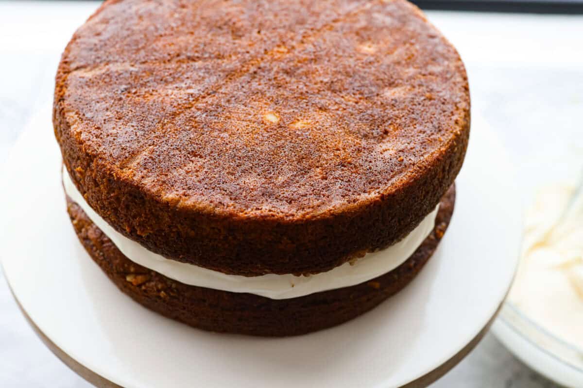If you’ve never had hummingbird cake, just know it’s one of those cakes people take a bite of and immediately ask for the recipe. It’s soft, sweet, packed with banana and pineapple, and topped with a cream cheese frosting that is to die for! Second layer of cake added to on top of the layer of frosting.
