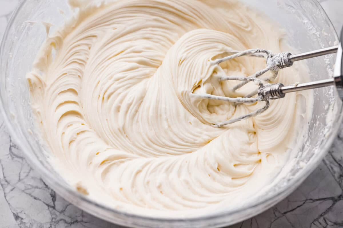 If you’ve never had hummingbird cake, just know it’s one of those cakes people take a bite of and immediately ask for the recipe. It’s soft, sweet, packed with banana and pineapple, and topped with a cream cheese frosting that is to die for! Cream cheese frosting all mixed together ready to go on the cake.