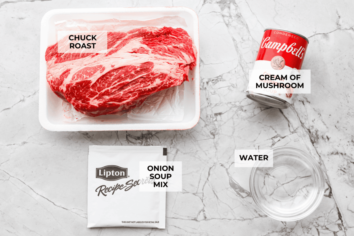 This 4 Ingredient Mushroom Beef is just like how my grandma used to make her Sunday roast, simple and cozy. You toss it all in the crockpot, and it comes out melt in your mouth tender with a rich gravy thatโs perfect over everything. Overhead shot of labeled ingredients.