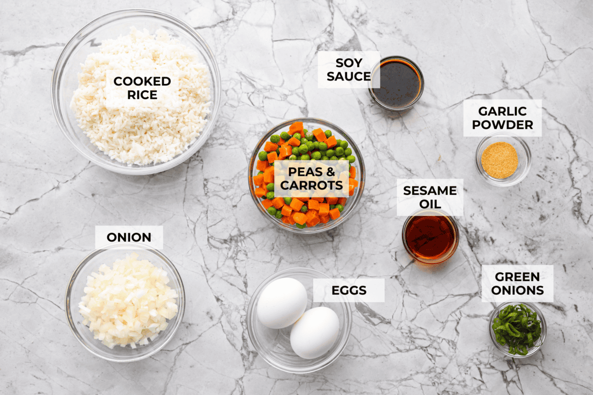 Did you know you can make fried rice in the air fryer? My Air Fryer Fried Rice recipe takes something already simple and makes it even easier. You get golden, slightly crispy rice, tender veggies, and the best flavor with hardly any effort. Overhead shot of labeled air fryer fried rice ingredients.
