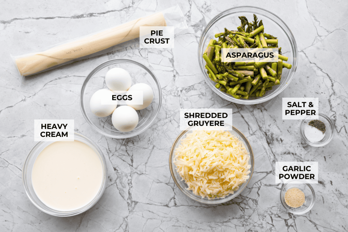 My asparagus quiche is one of those recipes I wait all year to make. Itโs creamy, cheesy, and those bright green asparagus pieces make every slice feel fresh and so good. Itโs simple, itโs pretty, and I love making it for a spring brunch! Overhead shot of labeled ingredients.