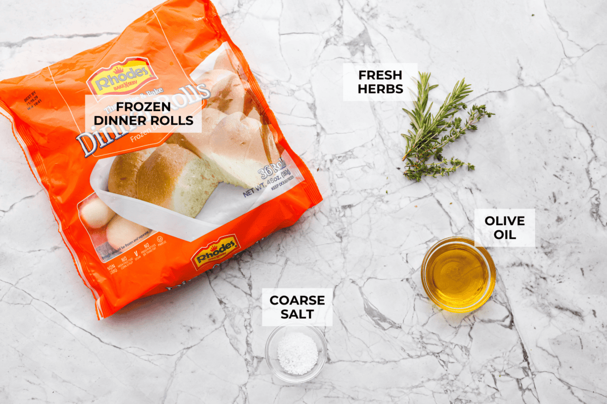 This slow cooker focaccia is the easiest way to get homemade bread on the table! Frozen dinner rolls transform into a pillowy, herb-flecked loaf with barely any effort. Just drizzle, dimple, and let your slow cooker do the rest. Overhead shot of labeled ingredients.