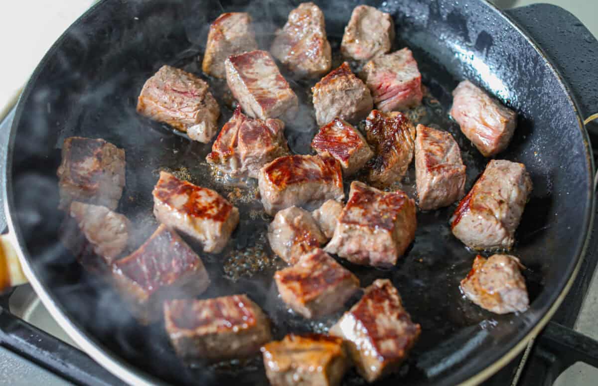 These marry me steak bites bring the flavor! Juicy, seared steak is tossed in a rich, creamy sauce with sun-dried tomatoes and bold, layered flavor. They're quick to make and perfect for spooning over potatoes or soaking up with veggies. Steak bites searing in a skillet.
