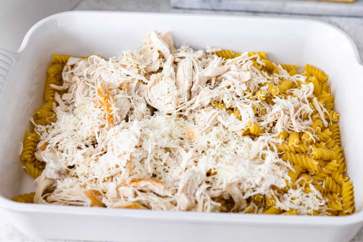 This baked Olive Garden chicken is pure comfort food made easy! It uses Olive Garden Italian dressing and just 5 other ingredients to create a creamy, cheesy pasta bake everyone loves. Quick prep, one dish, and big flavor in every bite! Pasta and shredded chicken in a baking dish.