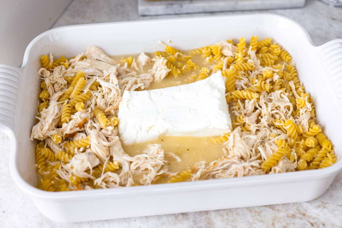 This baked Olive Garden chicken is pure comfort food made easy! It uses Olive Garden Italian dressing and just 5 other ingredients to create a creamy, cheesy pasta bake everyone loves. Quick prep, one dish, and big flavor in every bite! Block of cream cheese added to the pasta and chicken and dressing.