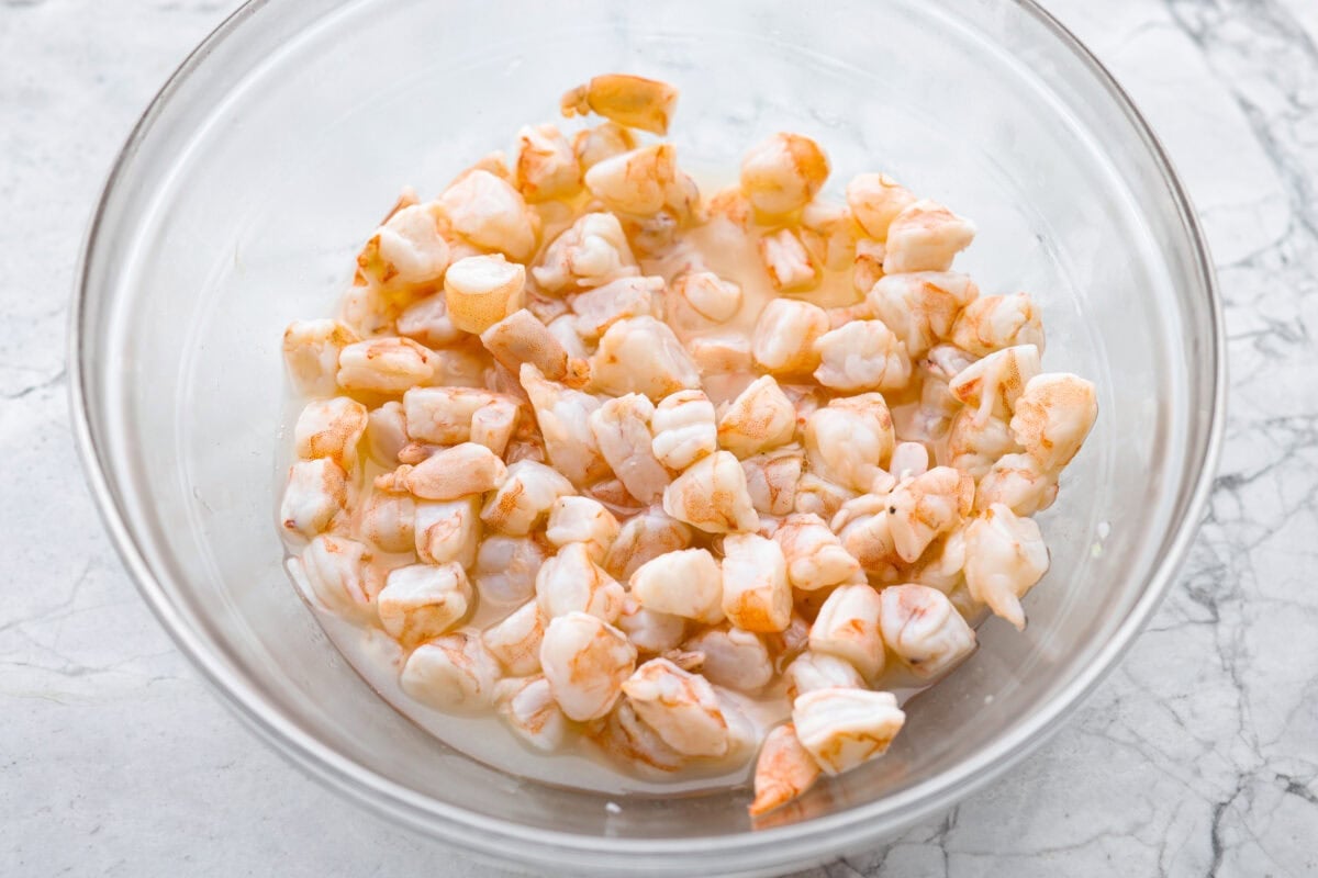 If you're anything like me, you LOVE shrimp ceviche! My version has avocado and is fresh, bright, and has the most incredible flavor. It's the perfect no-cook dish for warm weather. Make it, trust me, you will thank me later! Shrimp being cooked in a bowl of lime juice.