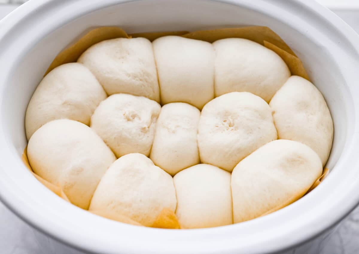 This slow cooker focaccia is the easiest way to get homemade bread on the table! Frozen dinner rolls transform into a pillowy, herb-flecked loaf with barely any effort. Just drizzle, dimple, and let your slow cooker do the rest. Rolls risen and fluffy.