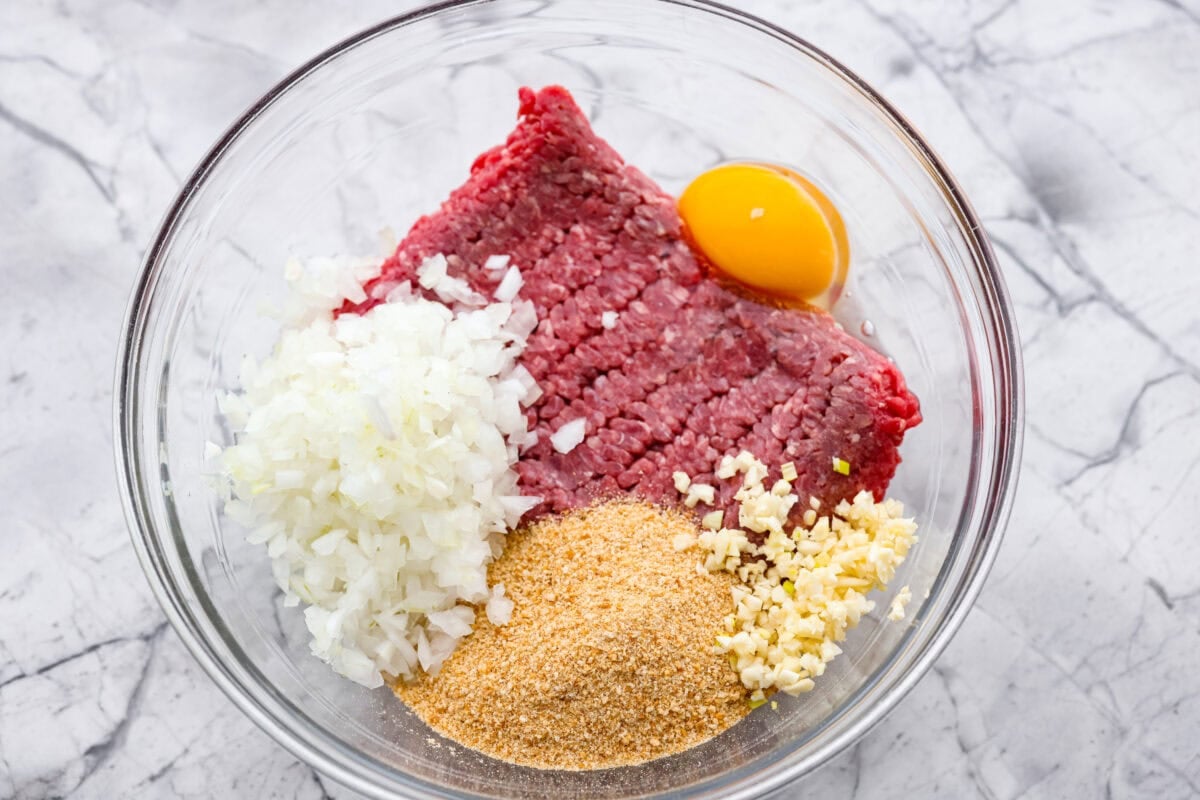 These sweet and sour meatballs are one of those dinners I pull out when I need something easy, but I know everyone likes! They’re saucy, a little sweet, a little tangy, and come together fast. Mixing bowl with ground beef, egg, breadcrumbs, onion, and garlic.