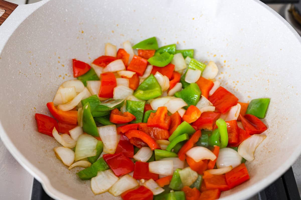 These sweet and sour meatballs are one of those dinners I pull out when I need something easy, but I know everyone likes! They’re saucy, a little sweet, a little tangy, and come together fast. Veggies diced and bing cooked in a wok.