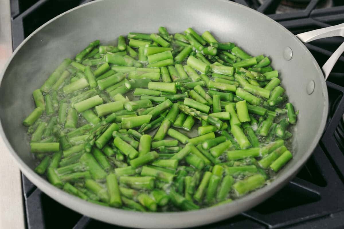 My asparagus quiche is one of those recipes I wait all year to make. Itโs creamy, cheesy, and those bright green asparagus pieces make every slice feel fresh and so good. Itโs simple, itโs pretty, and I love making it for a spring brunch! Asparagus cooking in a skillet on the stove.
