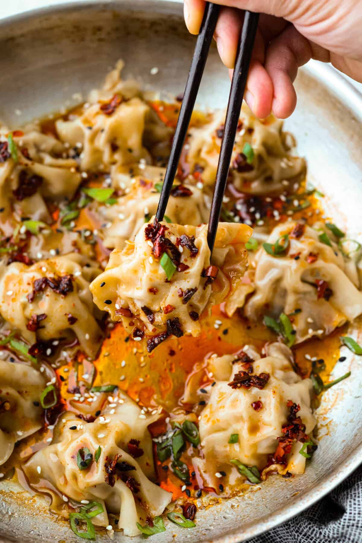 Blanket dumplings are a viral dumpling hack where you cook the filling and press the wrappers right on top. They are the ultimate shortcut to homemade dumplings, ready in just 30 minutes! Trust me, you will want to make these! Someone lifting a blanket dumpling out of the pan with chopsticks.