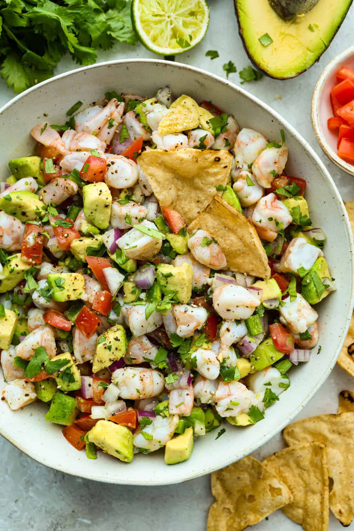 Bowl of shrimp ceviche with a couple of tortilla chips garnishing it. 