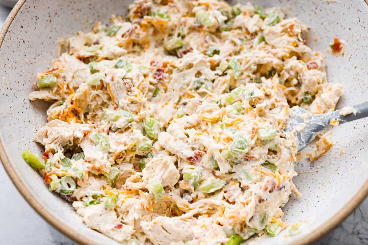 This crack chicken salad has no business being this good! Itโs creamy, packed with ranch, bacon, and cheddar, and disappears way too fast. Pile it on a croissant or eat it straight from the bowl. I promise I won't judge! All of the ingredients for crack chicken salad all mixed together.
