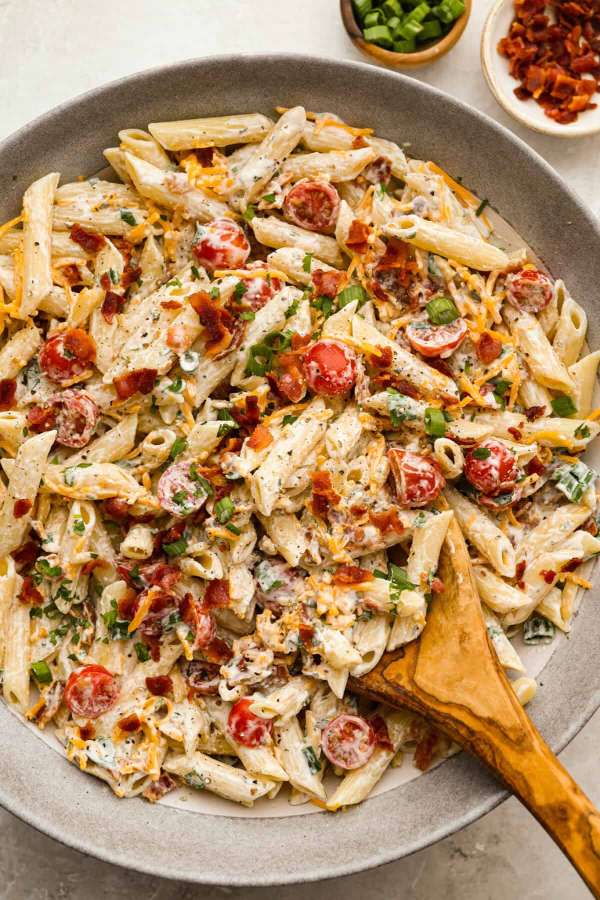 If there’s one side dish that disappears fast, it’s this million dollar pasta salad. It’s packed with crispy bacon, sharp cheddar, fresh veggies, and a creamy dressing that ties it all together. It’s sure to steal the spotlight at any table! Large bowl of creamy million dollar pasta salad.