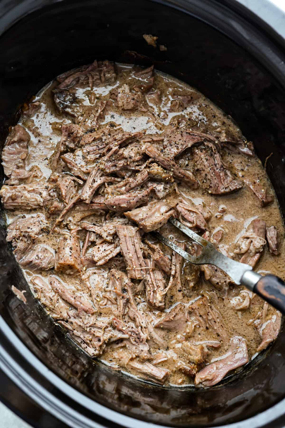 This 4 Ingredient Mushroom Beef is just like how my grandma used to make her Sunday roast, simple and cozy. You toss it all in the crockpot, and it comes out melt in your mouth tender with a rich gravy thatโs perfect over everything. Shredded up 4 ingredient mushroom beef in a crockpot.