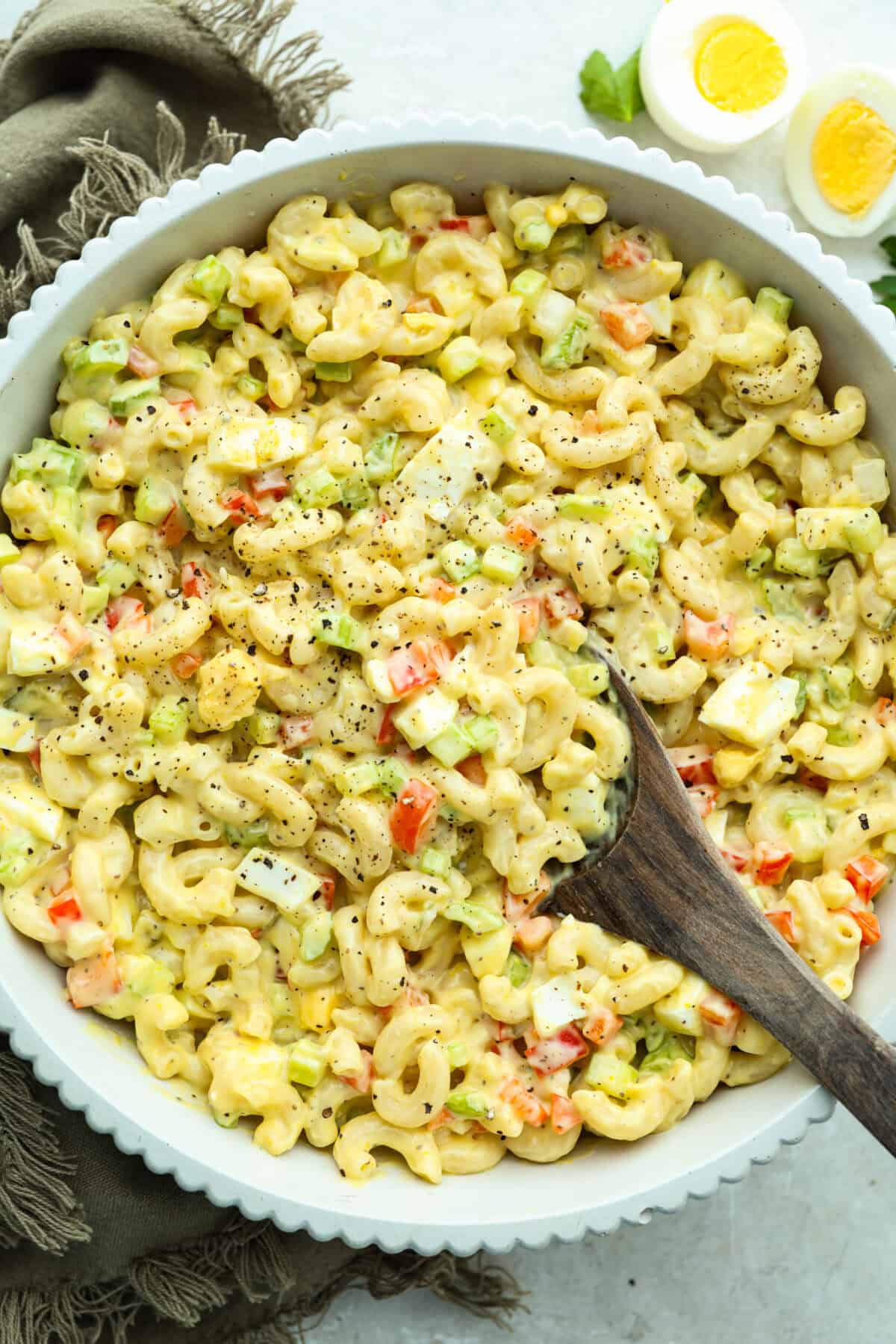 There’s something delightfully old school about Amish pasta salad. The sweet, tangy dressing, the macaroni, the chopped eggs, the crunchy celery. It tastes like the kind of recipe that’s been living in a handwritten church cookbook for decades. Bowl of Amish macaroni salad.