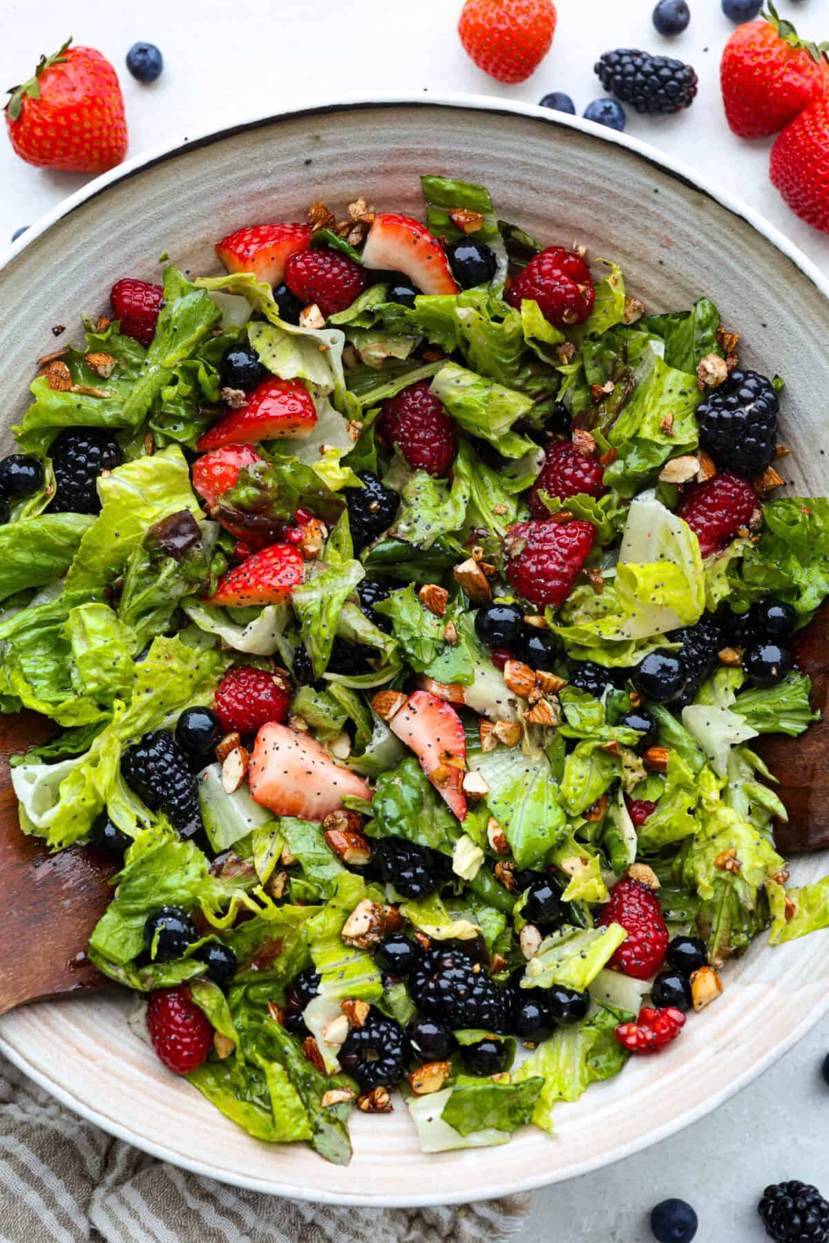 This copycat Zupa’s Nuts About Berries Salad is fresh, bright, and full of texture in every bite. Loaded with sweet berries, crunchy cinnamon almonds, crisp greens, and creamy poppyseed dressing, it tastes just like the restaurant favorite right at home! Large serving bowl of my copycat Zupa's nuts about berries salad.