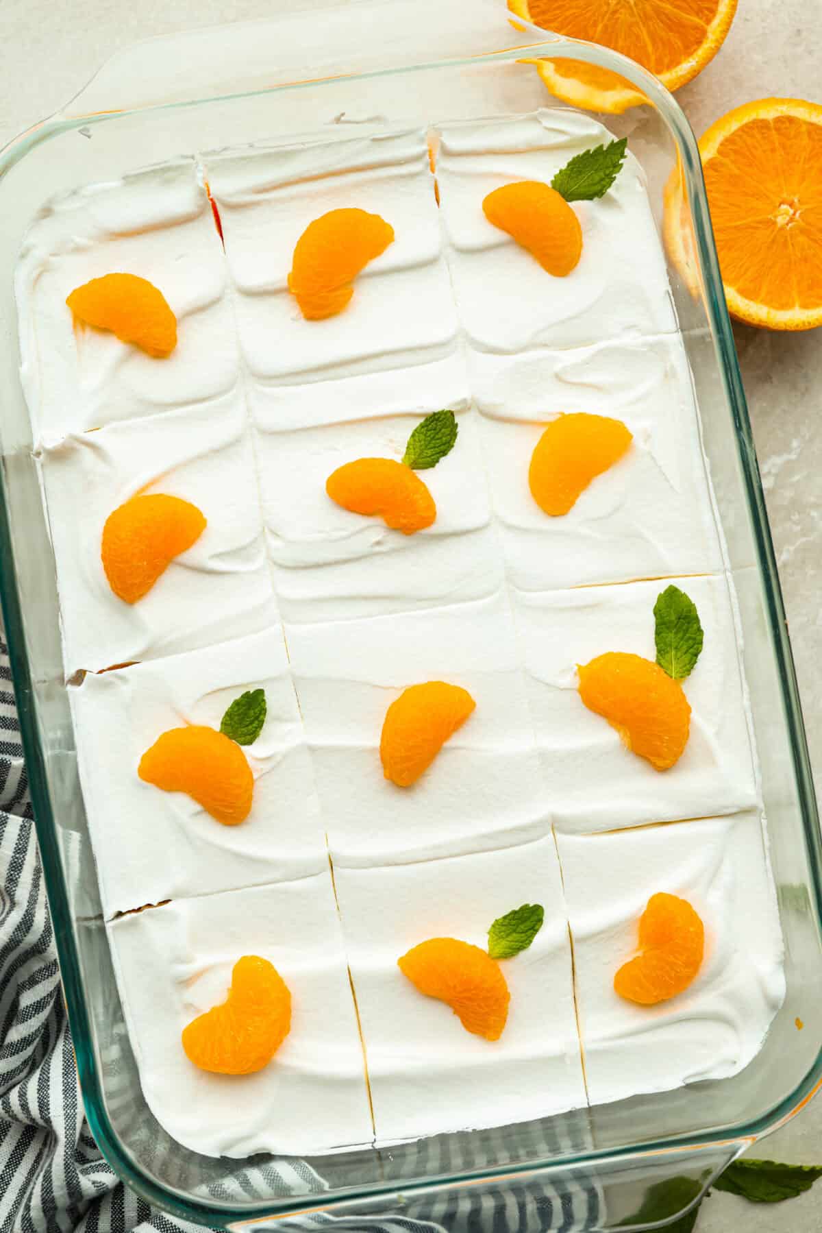 Orange creamsicle lush is sunshine in dessert form! With creamy orange layers, a buttery golden Oreo crust, and bright fresh citrus flavor, this easy no-bake dessert is a fun twist on my popular Lemon Lush thatโs perfect for summer. Orange creamsicle lush garnished with mandarin oranges and mint leaves.