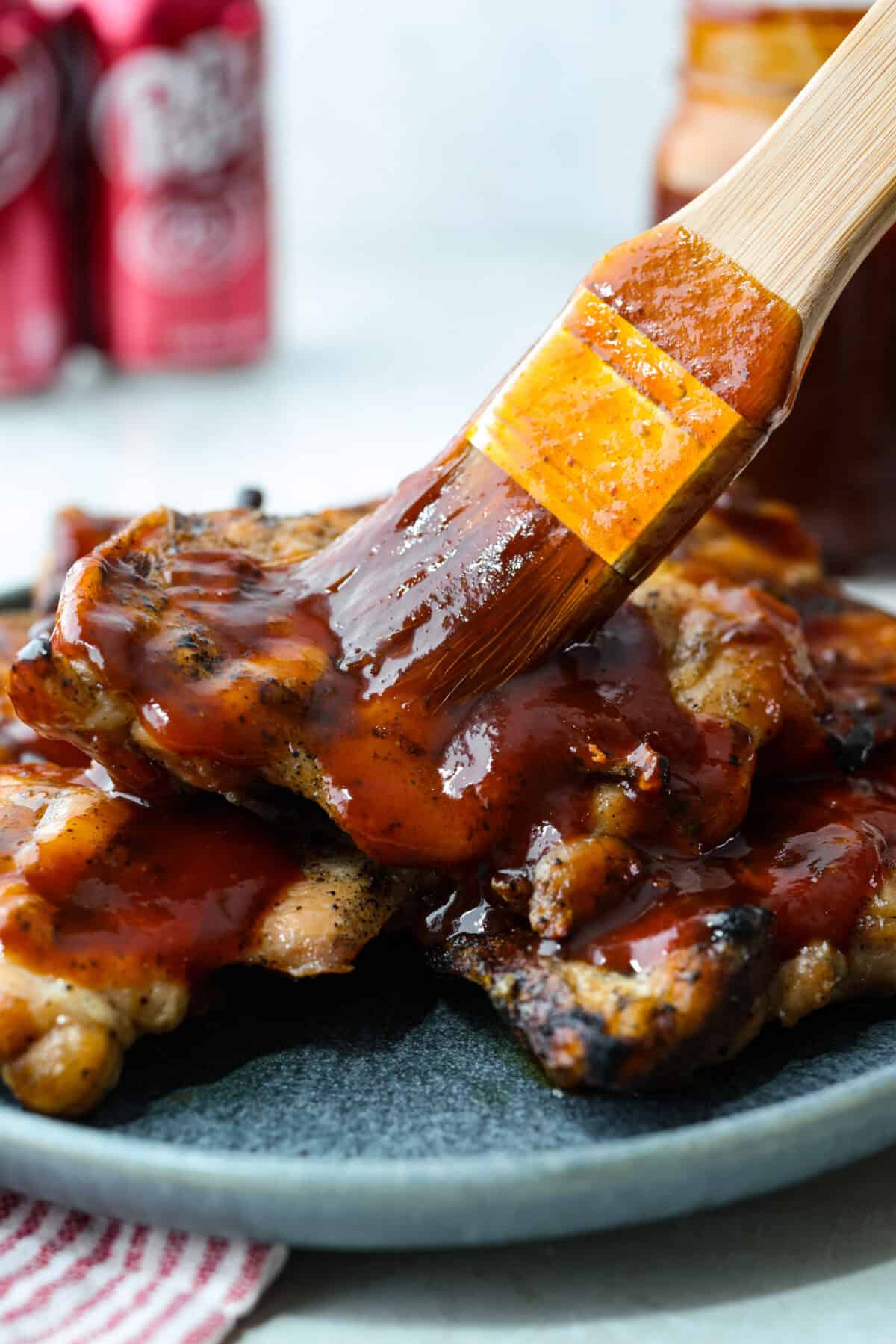 My Dr Pepper BBQ sauce is sweet, tangy, smoky, and seriously addictive! Made with simple ingredients and Dr Pepper for aย rich caramelized flavor. Itโs perfect for all your BBQ sauce needs! Someone spreading Dr Pepper BBQ sauce on some grilled chicken.