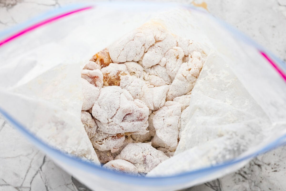Skip the drive-thru and make this copycat Panda Express orange chicken at home! Crispy chicken coated in a sweet, sticky orange sauce with a secret ingredient that makes it taste just like the real thing. Perfect for an easy takeout-style dinner the whole family will love. Chicken pieces in a bag with cornstarch and flour.