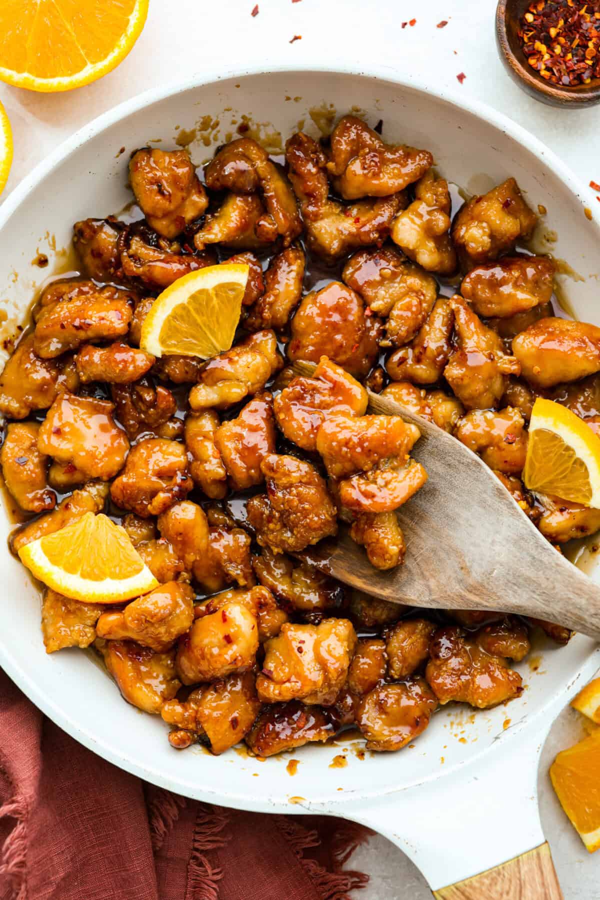 Skip the drive-thru and make this copycat Panda Express orange chicken at home! Crispy chicken coated in a sweet, sticky orange sauce with a secret ingredient that makes it taste just like the real thing. Perfect for an easy takeout-style dinner the whole family will love. Overhead shot of Panda Express orange chicken in a skillet.