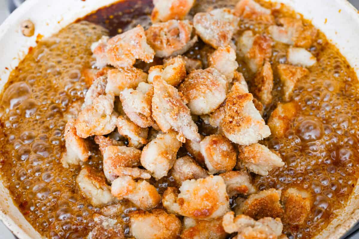 Skip the drive-thru and make this copycat Panda Express orange chicken at home! Crispy chicken coated in a sweet, sticky orange sauce with a secret ingredient that makes it taste just like the real thing. Perfect for an easy takeout-style dinner the whole family will love. Cooked chicken added back to the skillet with the sauce.