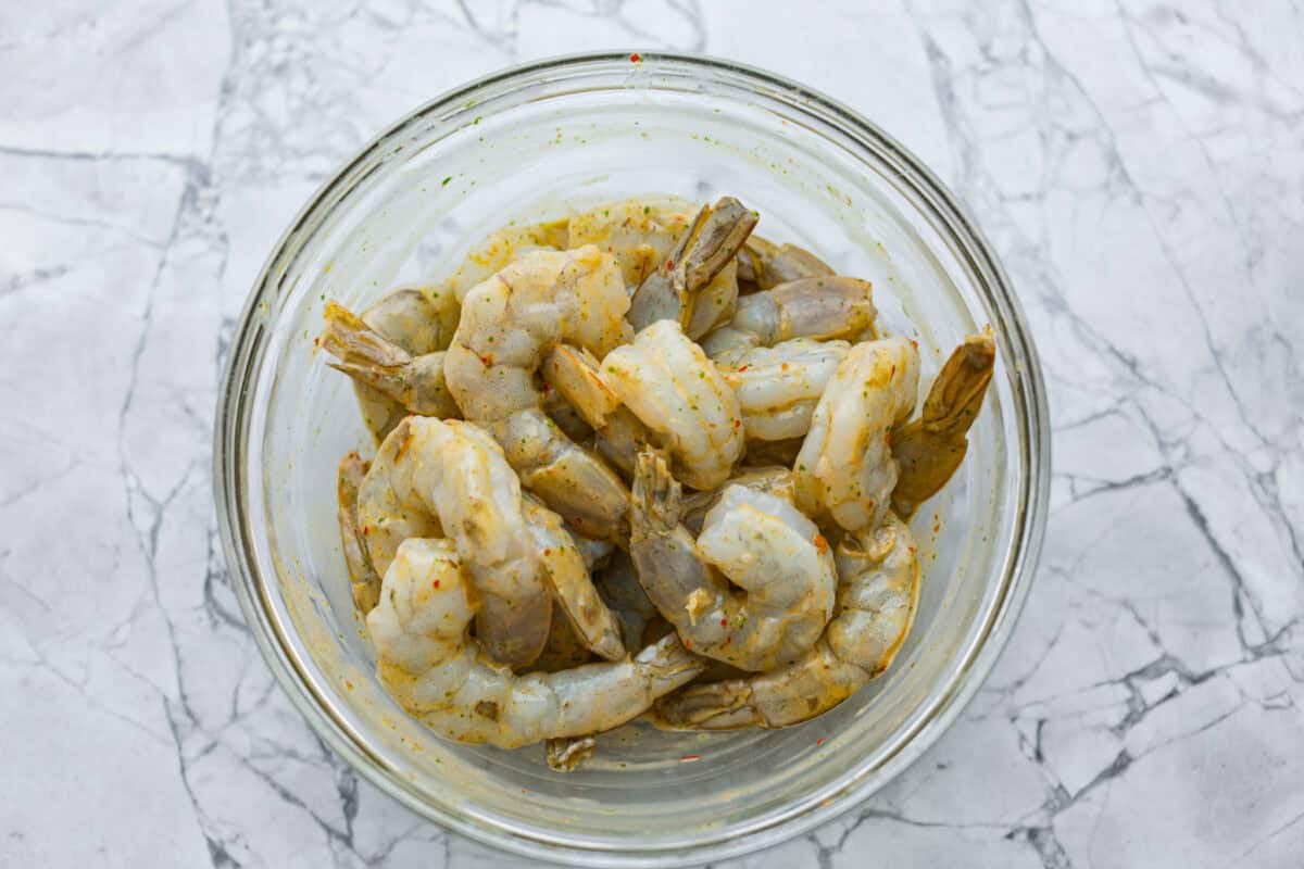 I love salads in the summer, and this grilled shrimp salad is such a good one. Itโs fresh, colorful, and filling without feeling heavy. And the dressing? Oh my gosh. The chipotle-lime flavor is so good, youโll want to pour it on everything. Raw shrimp in a bowl covered in the dressing as a marinade.