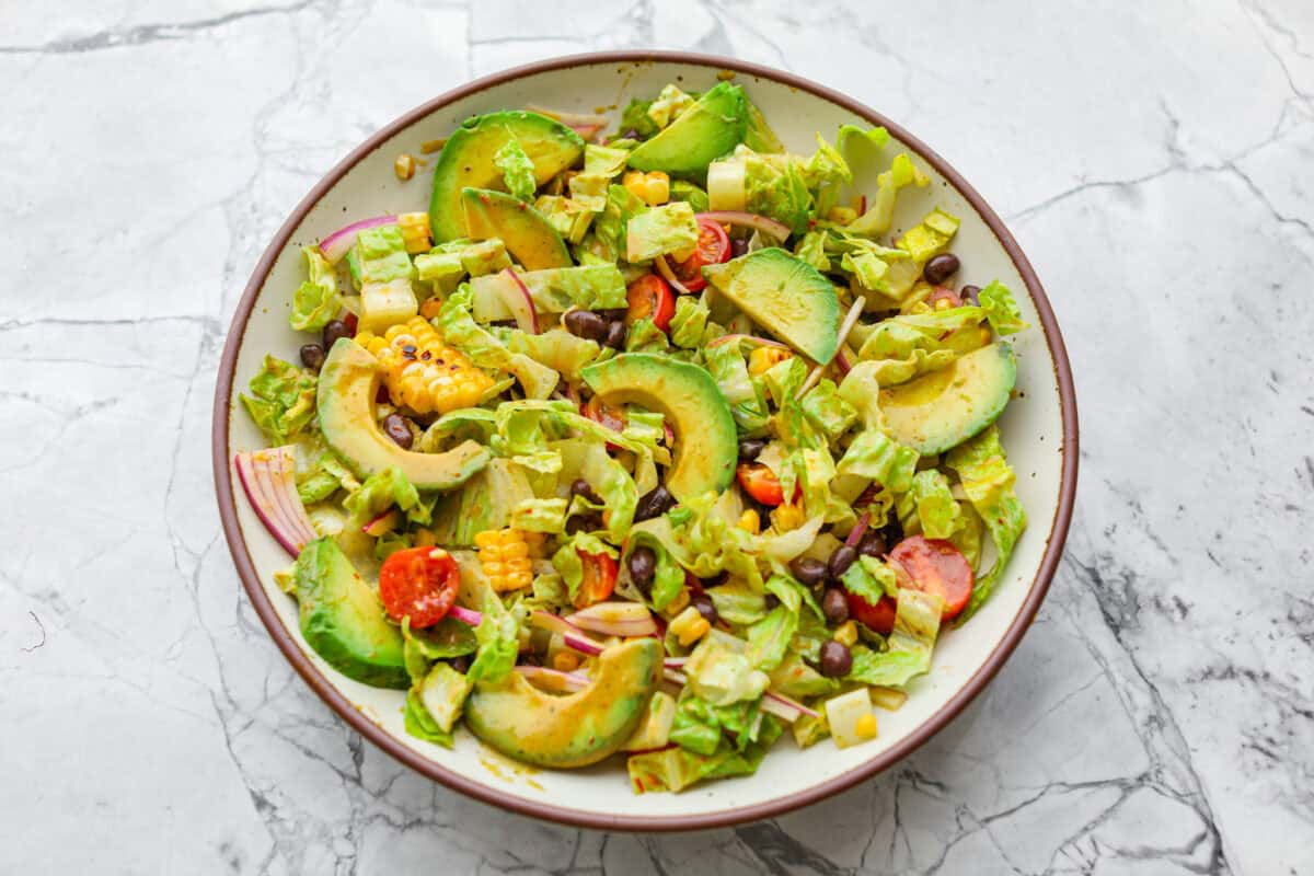 I love salads in the summer, and this grilled shrimp salad is such a good one. Itโs fresh, colorful, and filling without feeling heavy. And the dressing? Oh my gosh. The chipotle-lime flavor is so good, youโll want to pour it on everything. Salad ingredients added to a large serving bowl.