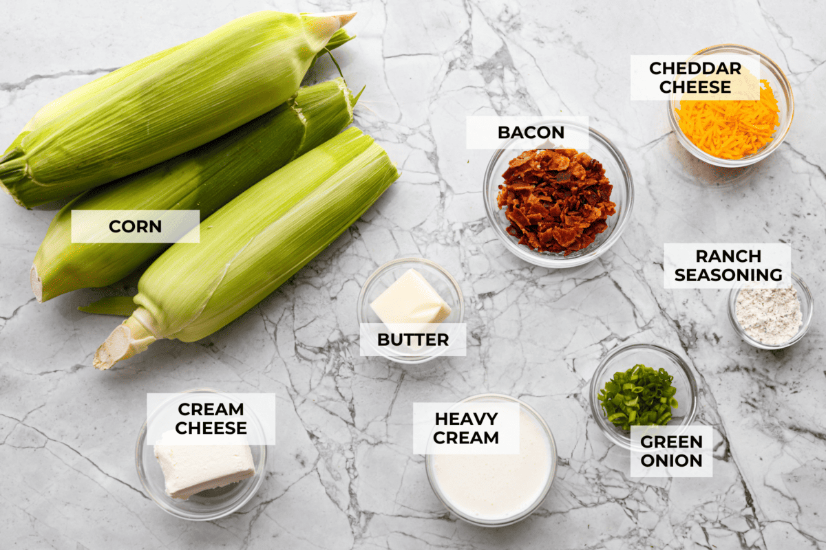 My crack corn on the cob takes summer corn to a whole new level! Smothered in a creamy ranch sauce and topped with bacon, cheddar, and green onions, it's the kind of side dish that disappears before the main course even hits the table. Overhead shot of labeled ingredients.