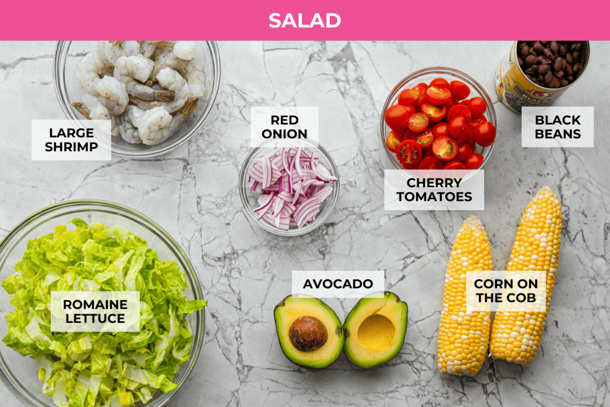 I love salads in the summer, and this grilled shrimp salad is such a good one. Itโs fresh, colorful, and filling without feeling heavy. And the dressing? Oh my gosh. The chipotle-lime flavor is so good, youโll want to pour it on everything. Overhead shot of labeled grilled shrimp salad ingredients.