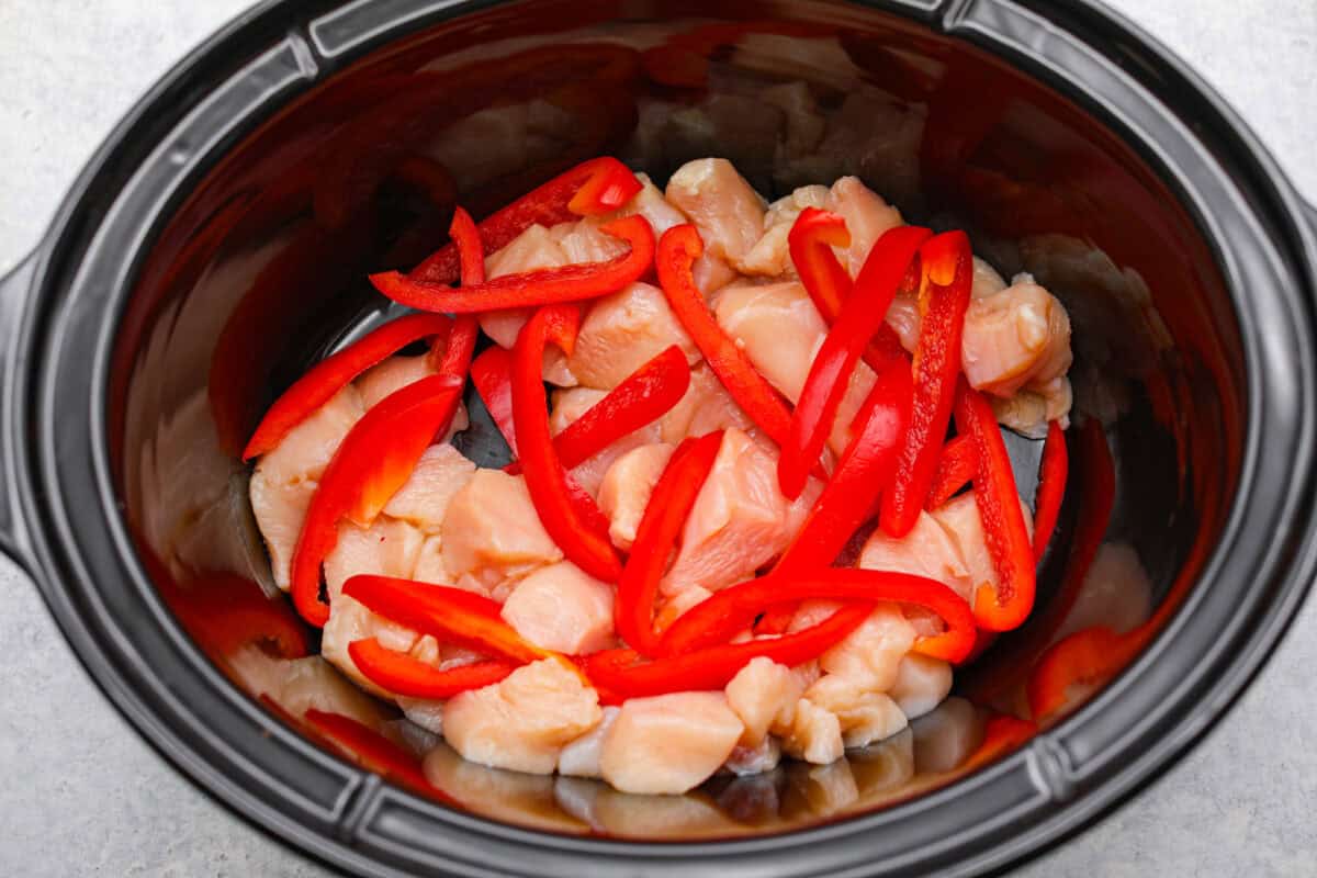 You asked, I listened! This slow cooker Thai peanut chicken got a serious glow-up! The sauce is creamy, savory, a little sweet, and packed with peanut coconut flavor. Iโd drink it with a straw if that were socially acceptable, but spooning it over rice, noodles or adding it to lettuce wraps is probably the better dinner move. Chicken and peppers added to the slow cooker.