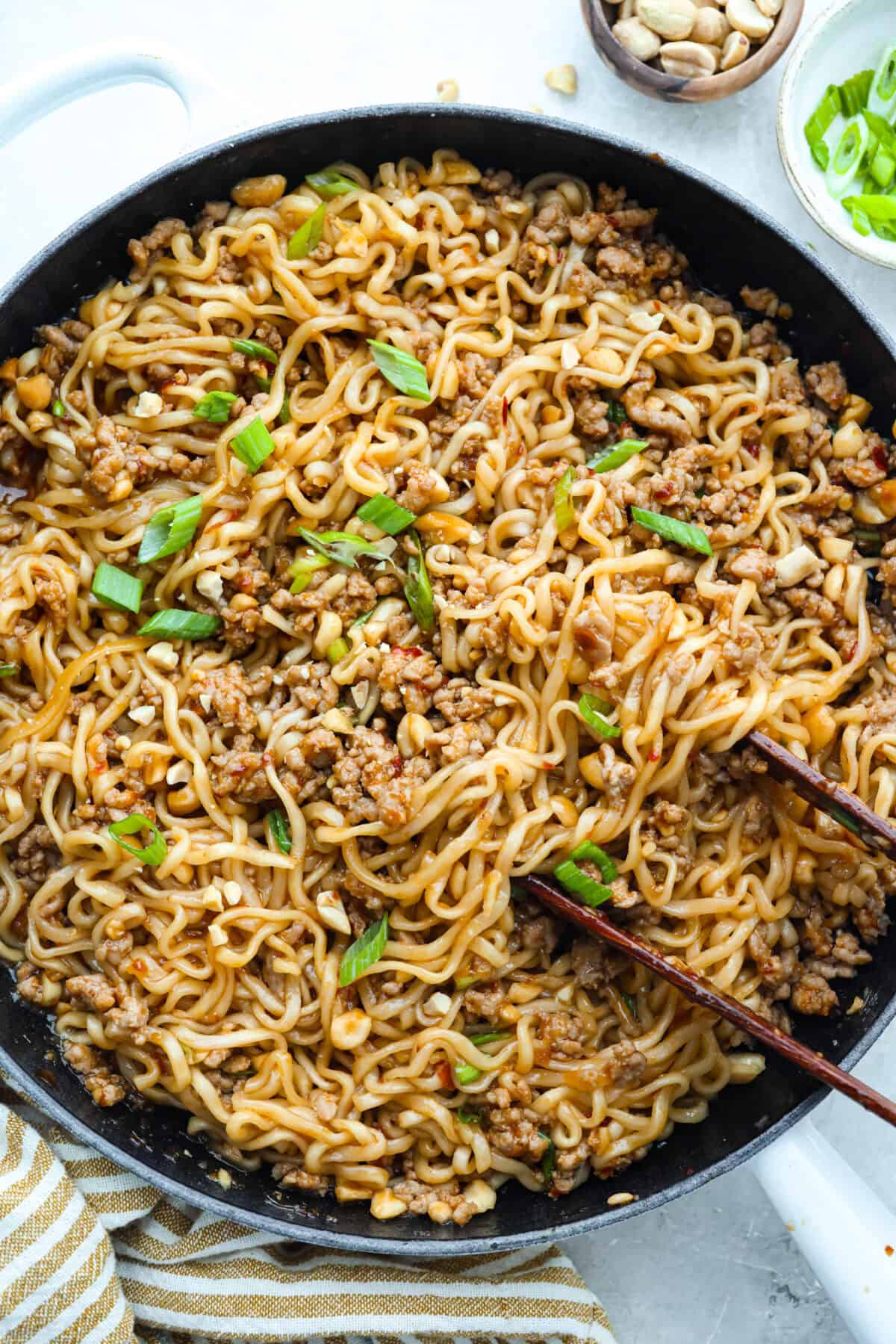 These dragon noodles are the ultimate weeknight dinner when youโre craving big flavor fast. Tender noodles, spicy-sweet sauce, and savory pork come together for a dish thatโs fast, fiery, and seriously addictive. Pan of dragon noodles topped with sliced green onions.