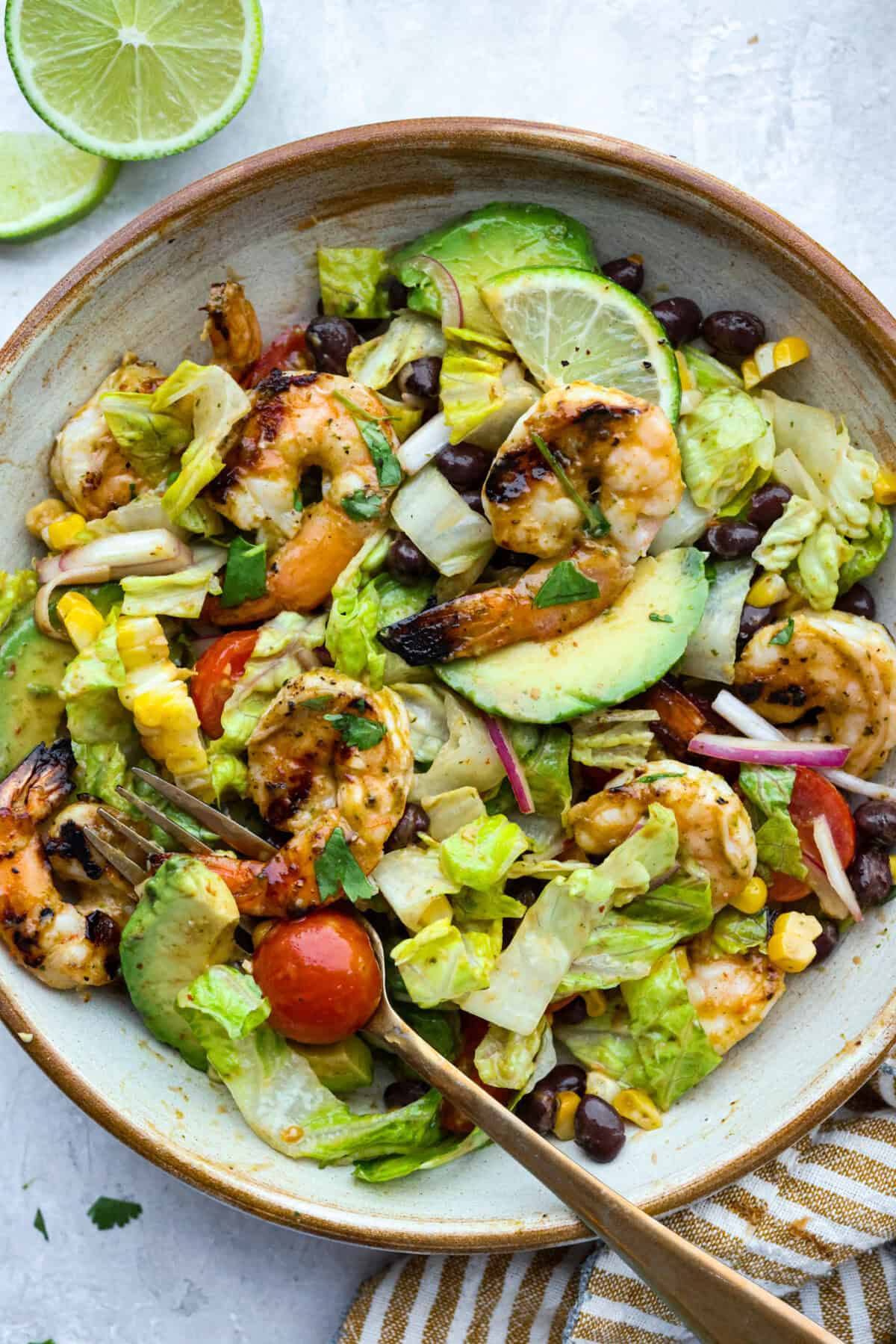 I love salads in the summer, and this grilled shrimp salad is such a good one. Itโs fresh, colorful, and filling without feeling heavy. And the dressing? Oh my gosh. The chipotle-lime flavor is so good, youโll want to pour it on everything. Serving bowl of grilled shrimp salad.