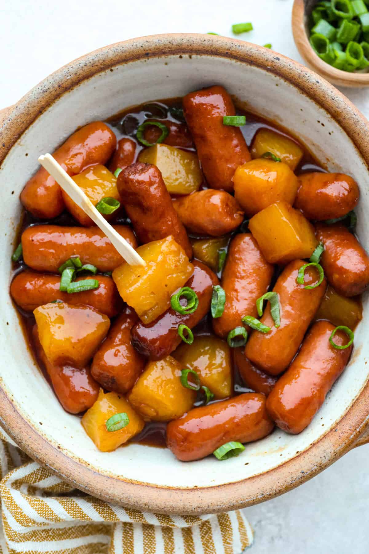 Don't be surprised if these Hawaiian Lil' Smokies steal the show! Slow cooked in a sweet and tangy pineapple BBQ sauce, they're bite-sized, irresistible, and dangerously easy to snack on. Bowl of hawiian lil' smokies.