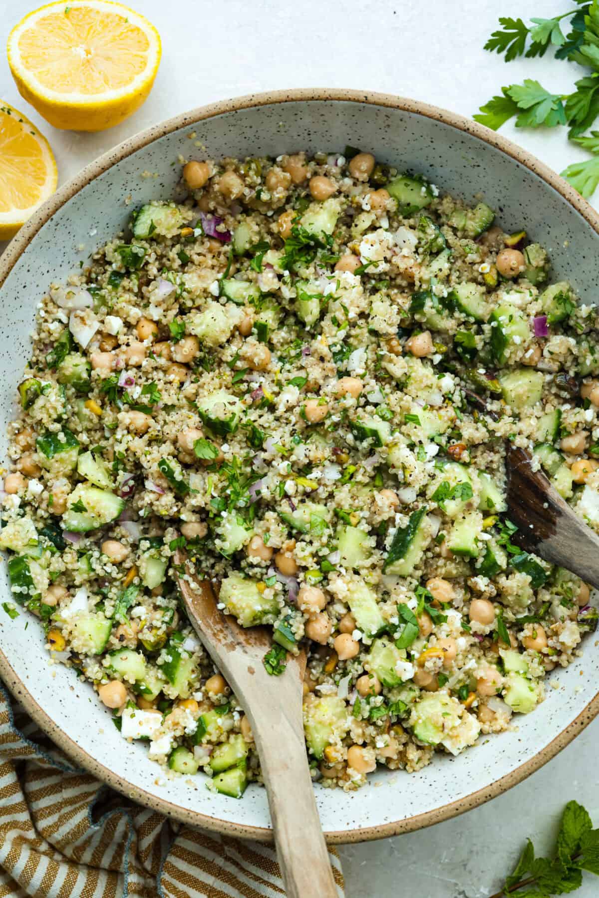 This Jennifer Aniston Salad is light, fresh, and perfect for summer lunches. Itโs packed with veggies, chickpeas, herbs, pistachios, and feta, then tossed in a simple lemon dressing that makes everything taste bright and delicious. Large bowl of Jennifer Aniston salad with wooden serving spoon.