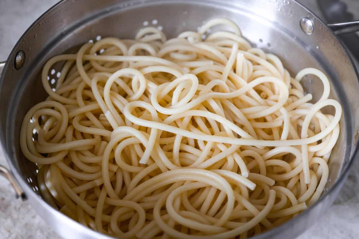 My 5-ingredient miso pasta turns pantry staples into something you'd swear came from a restaurant kitchen. Butter, garlic, and miso melt together into a rich, savory sauce that clings to every strand of bucatini. Colander with cooked noodles in it.