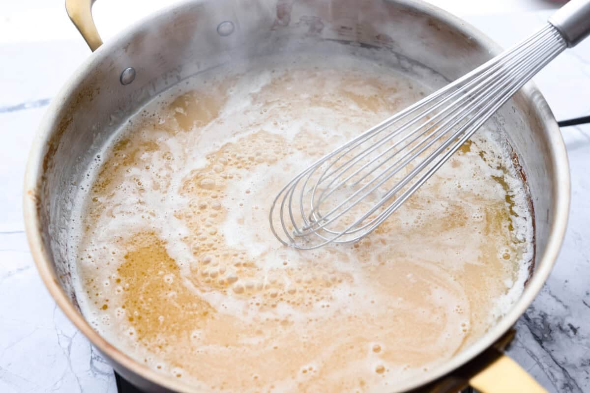 My 5-ingredient miso pasta turns pantry staples into something you'd swear came from a restaurant kitchen. Butter, garlic, and miso melt together into a rich, savory sauce that clings to every strand of bucatini. Miso and pasta water added to the skillet with butter and garlic.