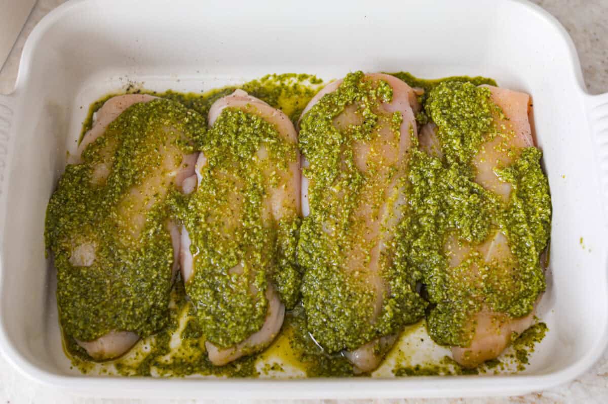 This pesto chicken is the kind of dinner you can assemble right in the baking dish and let the oven take it from there. Add the chicken, pesto, mozzarella, and tomatoes to one pan, bake until tender and bubbly, and dinner is done. Pesto smothered across the top of the chicken breasts.