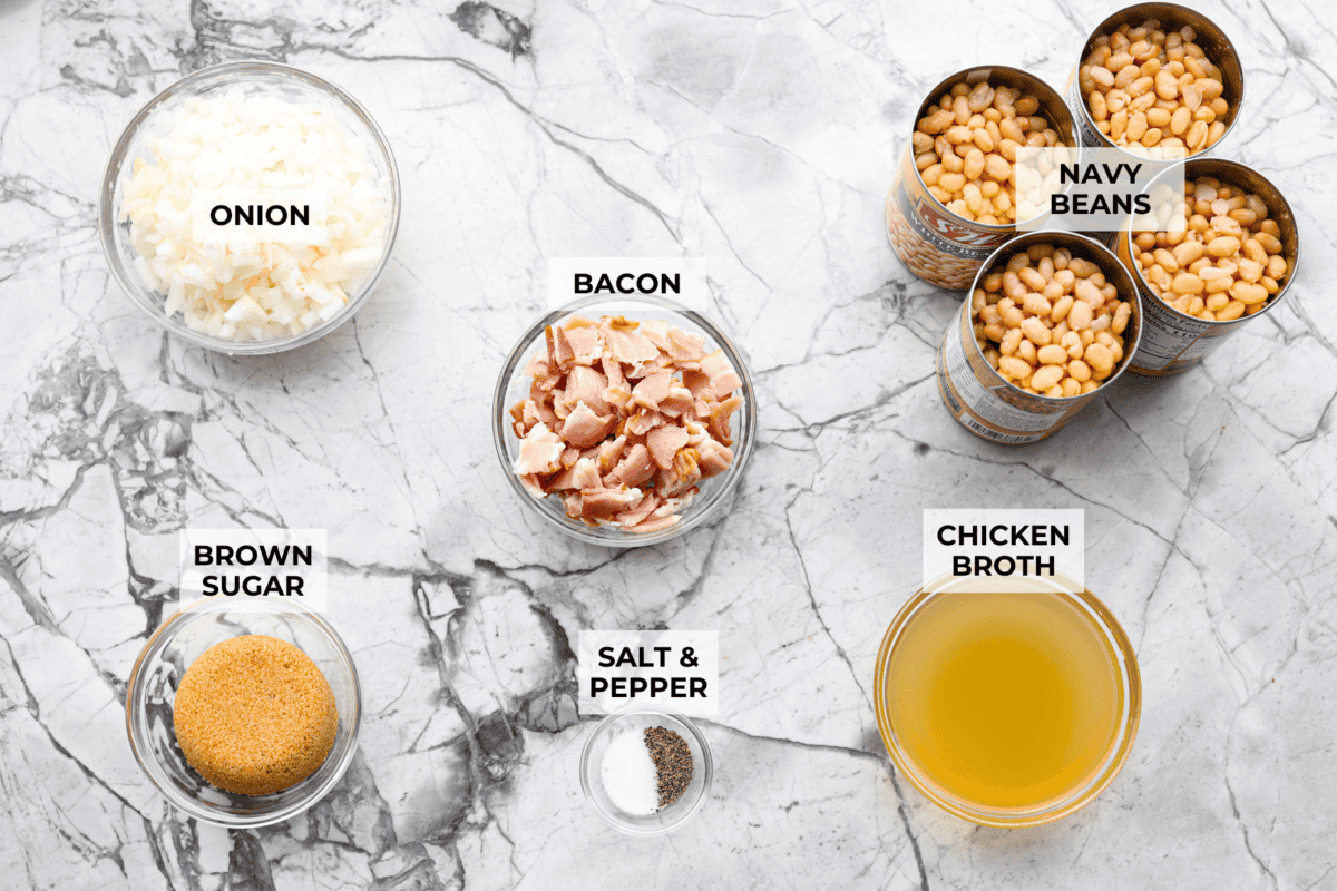 You're going to want this Copycat Grandma Brown’s Famous Baked Beans recipe in your life! It’s sweet, smoky, simple, and the perfect side dish for BBQs, summer cookouts, and every family get together. Overhead shot of labeled Grandma Browns baked beans ingredients.