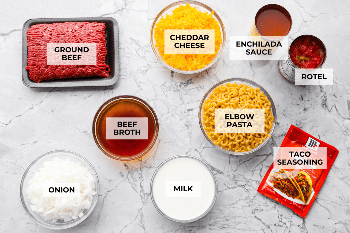 If your family loves tacos and mac and cheese, this one pan taco mac is about to become a weeknight favorite! It's cheesy, hearty, packed with Tex-Mex flavor, and comes together in one skillet in just 30 minutes. Overhead shot of labeled taco mac ingredients.