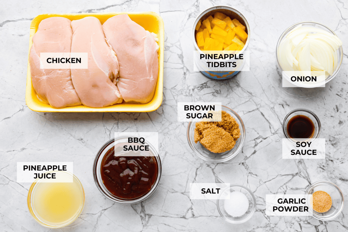 Slow cooker Aloha chicken is sweet, smoky, and so easy to throw together! Tender chicken cooks with pineapple, onion, and barbecue sauce until it’s full of flavor and ready to shred. Serve it over rice for a simple dinner the whole family will love. Overhead shot of labeled ingredients.