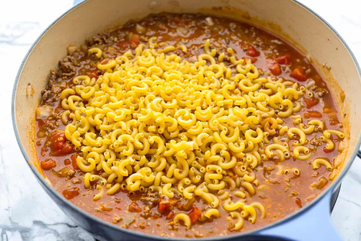 If your family loves tacos and mac and cheese, this one pan taco mac is about to become a weeknight favorite! It's cheesy, hearty, packed with Tex-Mex flavor, and comes together in one skillet in just 30 minutes. Macaroni noodles added to the skillet.