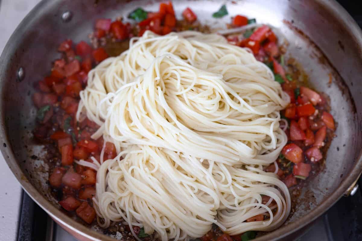 If you have fresh summer tomatoes sitting on your counter, this is your sign to make this Bruschetta Chicken Pasta. It's light, fresh, and shows that simple ingredients can make the best meals. Cooked noodles added to the pan with the tomato mixture.